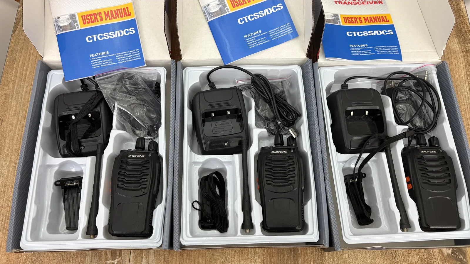 Los tres kits Baofeng BF-888S abiertos, con handies, bases de carga, antenas, clips, correas, auriculares y manuales