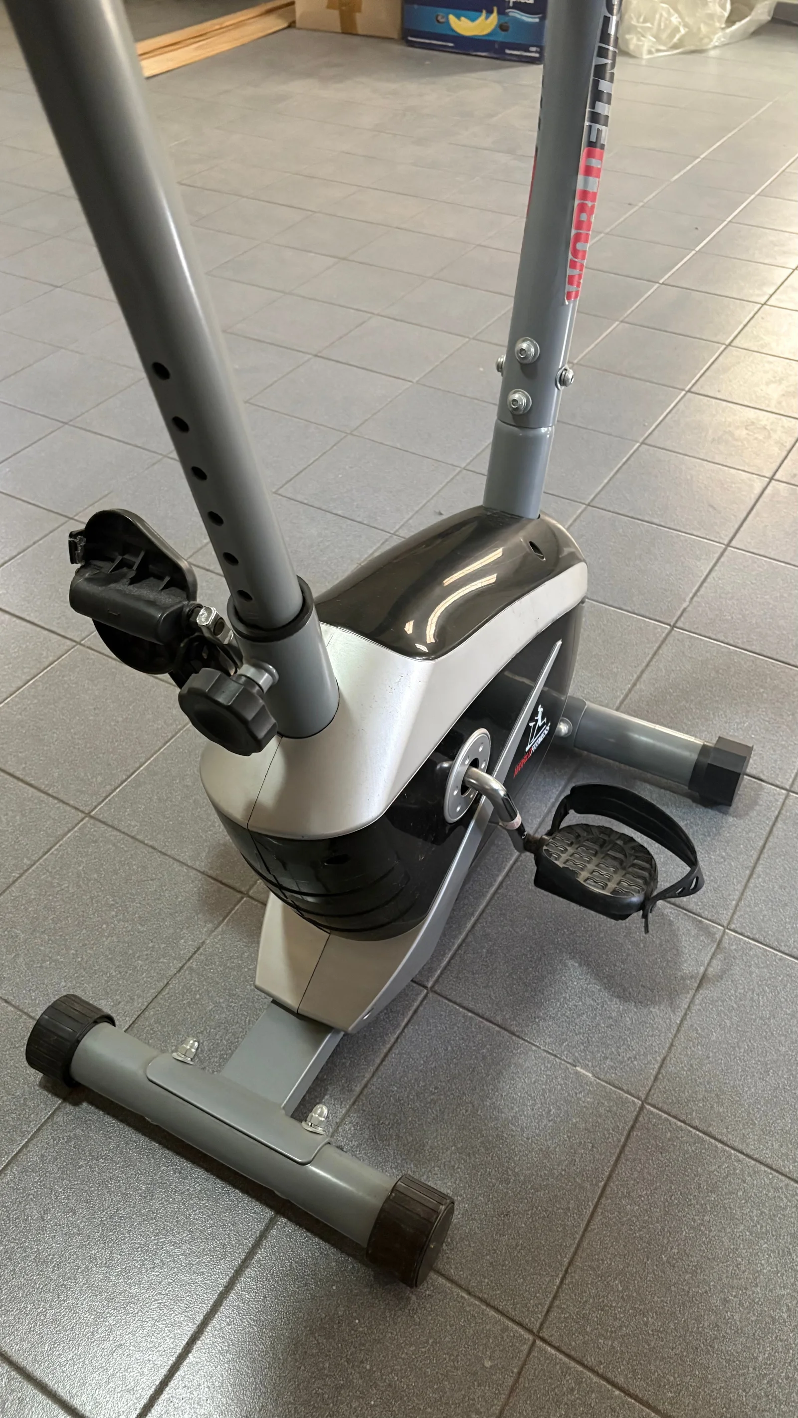 Detalle de los pedales con correas, la base y el ajuste de altura del asiento de la bicicleta